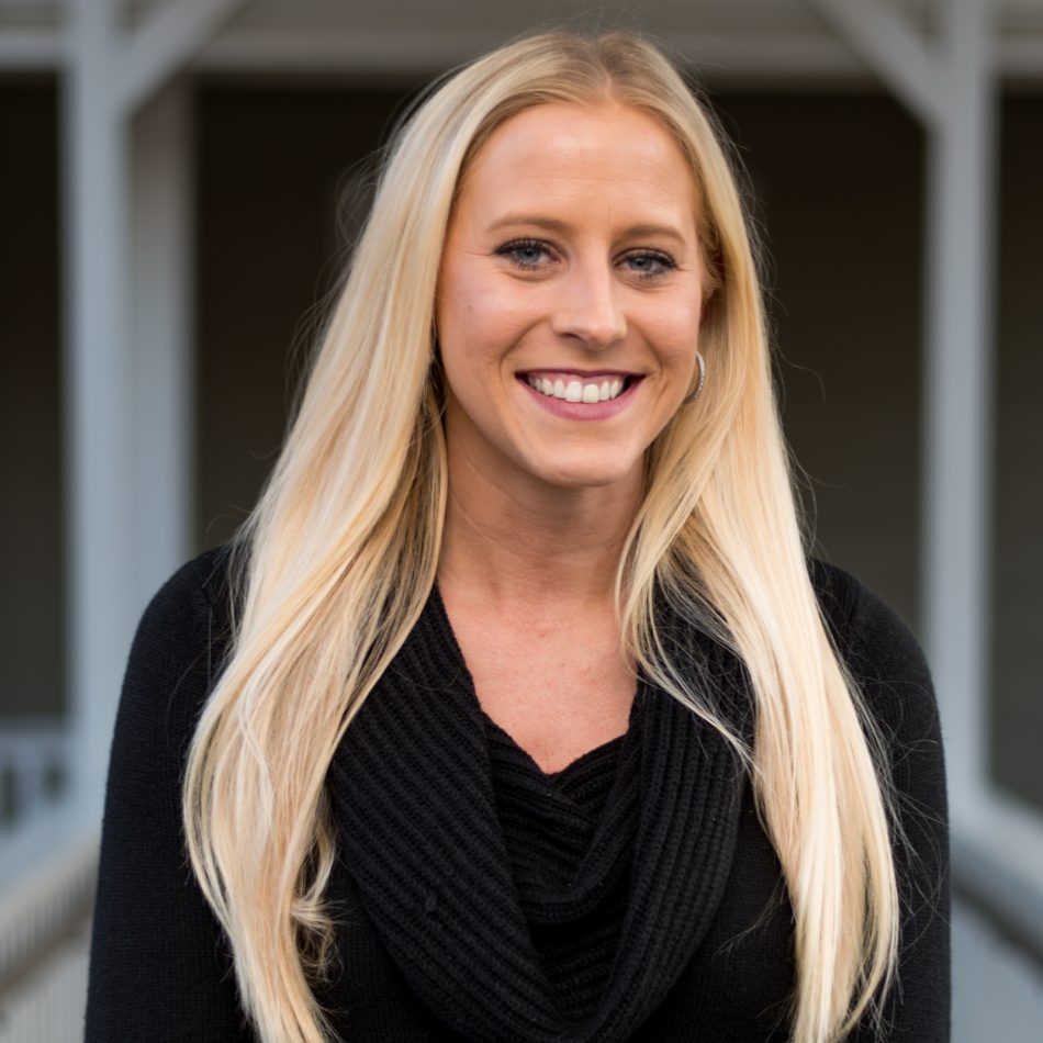 Happy young woman with long blonde hair wearing a black sweater
